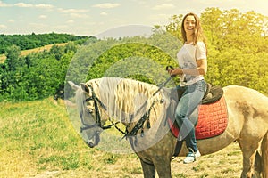 the rider on the white horse. Young horsewoman riding on white horse, outdoors view. girl on white horse runs free