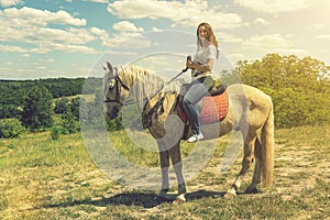 the rider on the white horse. Young horsewoman riding on white horse, outdoors view. girl on white horse runs free