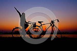 Riders cycling against sunset in silhouette with lots of negative space and dramatic sky