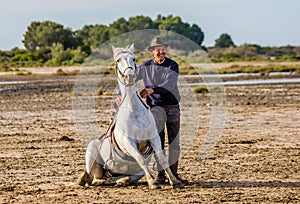 Riders near his White Camargue horse.