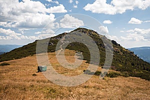 Ridge of the mountain and dry meadow with green caravan under the hill. Landscape photo of hill in national park in Slovakia