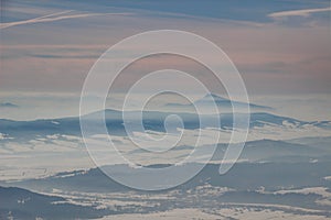 Ridges and conical peak under winter fog layers in Carpathians