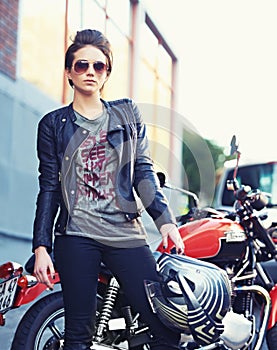 Riding with an attitude. Shot of a young and stylish female motorcycle rider outside.