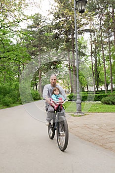 Riding bike with daddy. Little girl, father outdoors