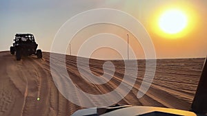 Riding buggies in the desert during sunset