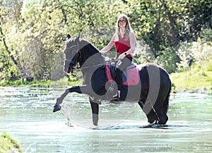 Riding girl and horse in river