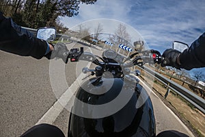 Riding a motorbike with a black fuel tank on a left turn asphalt road