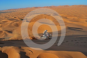 Riding motorbike in the sahara dunes photo