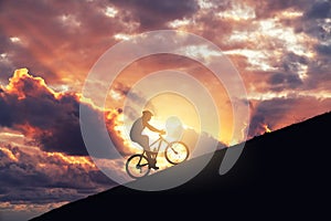 Riding mountain bike on a ramp against cloudy sky. Achieving the difficulty and improvement concept.