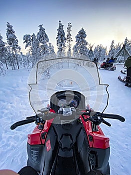 Riding a snowbike on a white frozen landscape in Lapland, Finland