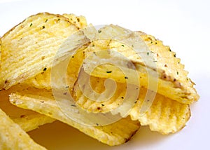 Riffled potato chips with spices on a white background