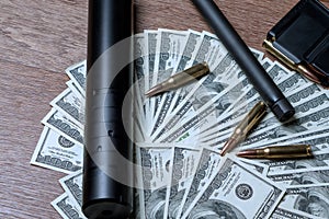 Rifle barrel, suppressor and cartridges on dollars. Concept for crime, contract killing, paid assassin, terrorism, war