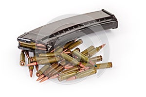 Rifle cartridges against the assault rifle magazine on white background