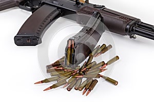 Rifle cartridges and magazine against the assault rifle, selective focus