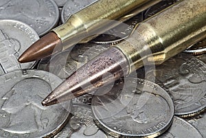 Rifle cartridges on a pile of American coins