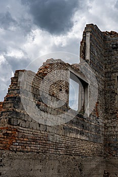 Rift in a brick wall. Close-up. Ruined red brick wall. The wreckage of the wall against the sky.