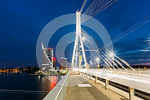 Riga Latvia. Close View Of Deserted Vansu Cable-Stayed Bridge In Bright Night Illumination Over The Daugava River