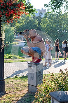 RIGA, LATVIA - JULY 26, 2018: The photographer ascended up to the electric cabinet in a city park