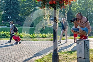 RIGA, LATVIA - JULY 26, 2018: The photographer ascended up to the electric cabinet in a city park