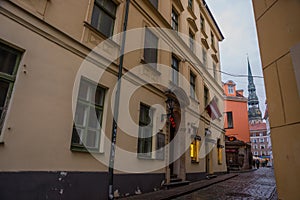 RIGA, LATVIA: Maza Miesnieku iela street. Narrow medieval cobbled street with tenement houses in the old town of Riga. Retro