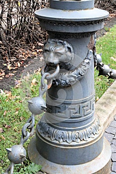 Riga, Latvia, November 2019. Closeup of a road post with a chain and a muzzle of a lion.