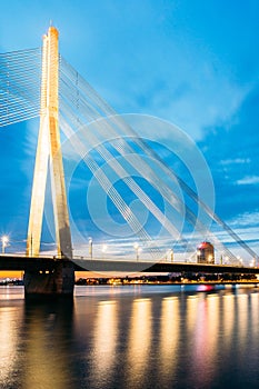 Riga Latvia. Scenic View Of Vansu Cable-Stayed Bridge In Night Illumination Over The Daugava River,