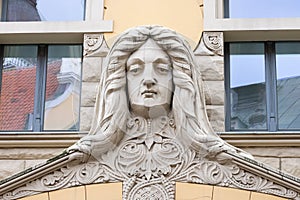 Riga, Latvia, September, 17, 2019: Building with face on facade in art nouveau style in the center of old town of Riga. Stone scul