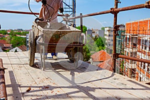 Rigger is fastening crane hooks to the wheelbarrow