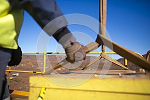 Rigger hand construction worker wearing heavy duty glove holding control a two tones yellow lifting sling
