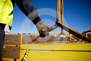 Rigger hand construction worker wearing heavy duty glove holding control a two tones yellow lifting sling