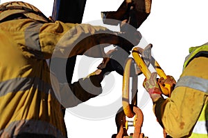 Rigger hands wearing a heavy duty safety protection glove while performing opening crane hook clip on open field with while backgr