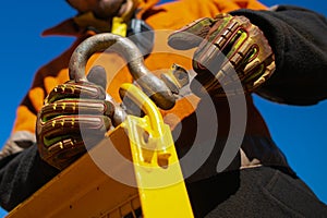 Rigger high risk worker wearing safety heavy duty glove, fastening tensioning pin into D- shape shackle