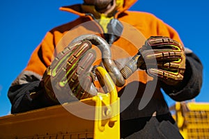 Rigger high risk worker wearing safety heavy duty glove, inserting pin into D- shape shackle