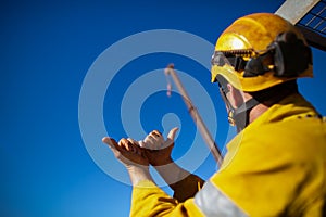 Rigger wearing safety fall protection helmet giving crane driver hand signal photo