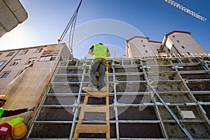 Rigger, worker climbed on wooden ladder to assembly demountable mold