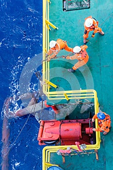 Riggers working on anchor handling on a construction wok barge at offshore Terengganu oil field during sunrise