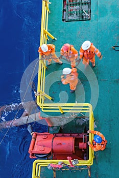 Riggers working on anchor handling on a construction wok barge at offshore Terengganu oil field during sunrise