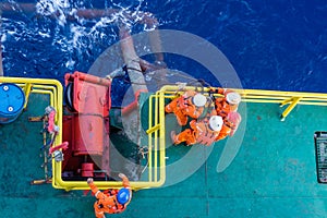 Riggers working on anchor handling on a construction wok barge at offshore Terengganu oil field during sunrise