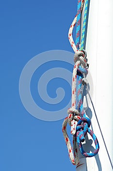 Rigging. Blue sky and white mast.