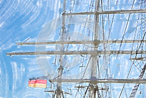 Rigging and masts of a big sailing ship in front of a blue sky w