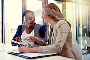 The right apps can offer the assistance you business needs. two businesswomen working together on a digital tablet in an