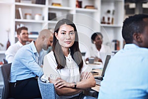 This is the right career for me. Portrait of a young businesswoman sitting in an office with her colleagues in the