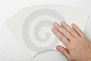 Right caucassian woman hand choosing a card from a fun arrenged over a white background