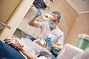 The right choice for your dental care needs. Attractive woman at the dental office. Dentist examining patient`s teeth in