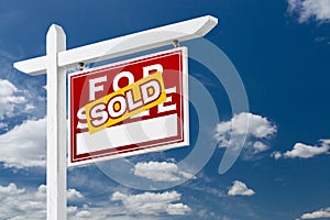 Right Facing Sold For Sale Real Estate Sign Over Blue Sky and Cl