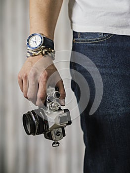 Right hand holding camera with watch and bracelet