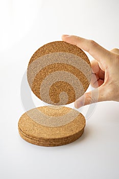 Right hand selecting round cork board on overlap
