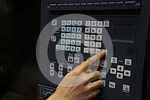 Right hand pressing buttons on a control panel CNC machine.