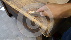 Right hand using sandpaper for wood restauration