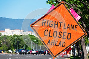 Right Lane Closed Ahead warning road sign on wide city street in urban neighborhood